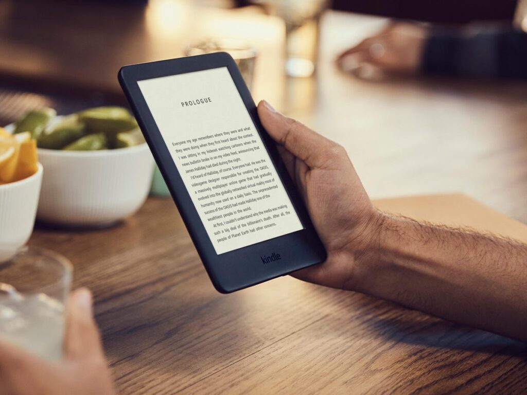 A person holding an e-book on their hand.