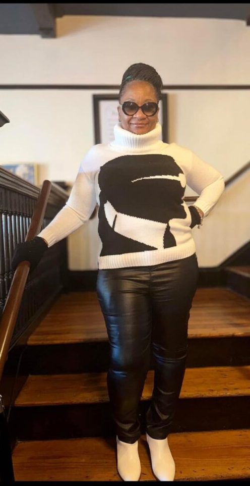 A woman standing on the stairs wearing black and white clothing.